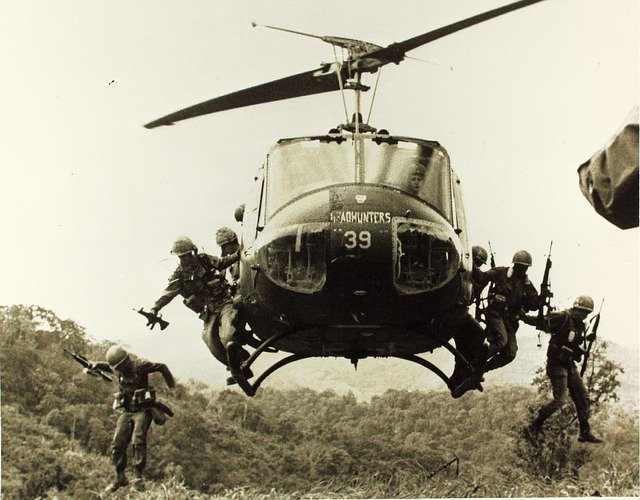 American soldier jumping from either side of a helicopter 